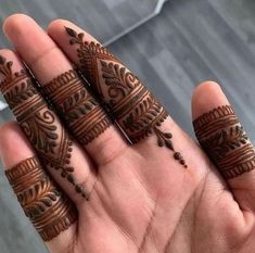 someone is holding their hands with henna tattoos on them