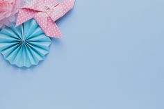 pink and blue paper flowers are on a light blue background