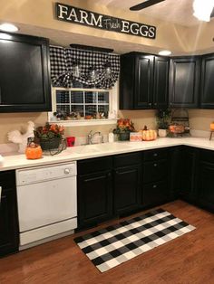 a kitchen with black cabinets and white appliances in the center is an area rug that says farm from eggs