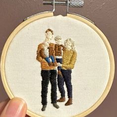 a hand embroidered picture of three people holding each other