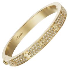 CARTIER LOVE BRACELET Cartier 'Love' bangle bracelet crafted in 18k yellow gold with gold screw tops and pave set round brilliant cut diamonds (D-F in color, VVS clarity) Signed Cartier, 750, with serial number and hallmarks The bracelet is presented with a Cartier box and certificate upon sale In 18k yellow gold and pavé of diamonds total 204 diamonds total 2 ct and weight gold 33 gr In size 16 Original at shop at 48.300€ If the robust locking mechanism and miniature screw heads that characteri Luxury Cartier Gold Bracelet With 17 Jewels, Cartier Love Bracelet Diamond Pave, Luxury Cartier Gold Bracelet For Wedding, Cartier Luxury Gold Bracelet For Formal Occasions, Luxury Bracelet Stack, Gold Designer Bracelet, Cartier Love Bracelet Diamond, Chopard Bracelet, Love Bracelet Cartier