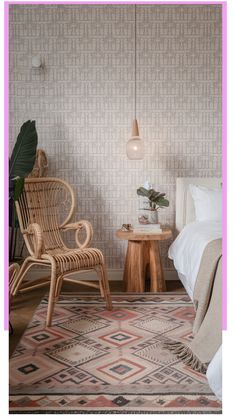 Cozy bedroom with a rattan chair, patterned rug, wooden side table, and hanging lamp.