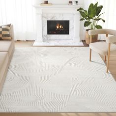 a living room with a white rug and fireplace in the corner, along with two chairs