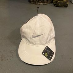 a white hat with a nike tag hanging from it's brimmed visor