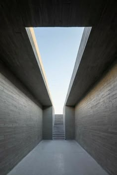 an empty hallway with stairs leading up to the sky