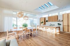 a living room filled with furniture next to a kitchen and dining room table in front of a sliding glass door