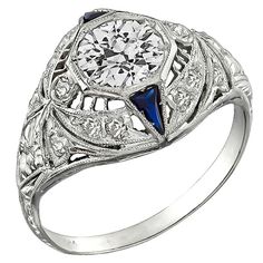 This fabulous platinum ring from the Art Deco era is centered with a sparkling GIA certified old European cut diamond that weighs 0.79ct. and is graded H color with VS1 clarity. The center diamond is accentuated by round cut diamond and trilliant cut sapphire accents. The ring is stamped PLATINUM and weighs 3.3 grams. It is a size 6 1/4, and can be resized. Inventory #29054ABSS Art Deco Diamond Ring Engagement, Diamond Sapphire Engagement Ring, Platinum Engagement Ring, Platinum Diamond Engagement Rings, Estate Rings, Art Deco Engagement, Sapphire Engagement Ring, Platinum Engagement Rings, Deco Engagement Ring