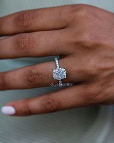 a woman's hand with a diamond ring on it