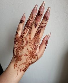 a woman's hand with henna tattoos on it