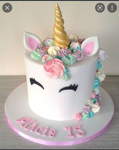 a birthday cake decorated with an unicorn's head and flowers