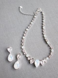 "This elegant necklace and the earrings set is hand made using fine Swarovski crystals in white opal and clear crystal mix. The necklace measures 16\" long and comes with the 2\" extender. The matching drop earrings measure 1 1/2\" long and 1/2\" wide. The set is available in gold, silver or rose gold finish. Also available with all clear crystals. - The listing is for the jewelry set only - For the matching belt please take a look here: https://www.etsy.com/listing/751689969/swarovski-crystal-b Elegant Crystal Embellished Jewelry For Gifts, Silver Crystal Bridal Necklace With Gemstones, Elegant Crystal Jewelry With Stones, Exquisite Crystal Jewelry With Matching Earrings, Elegant Teardrop Stone Jewelry, Elegant Bridal Necklace With Stones, Elegant Bridal Necklace With Stones For Wedding, Crystal Bridal Necklace With Stones For Wedding, Elegant White Jewelry With Sparkling Stones