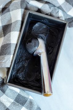 an ice cream dish with two spoons in it on a checkered cloth covered tablecloth