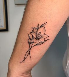 a woman's arm with a flower tattoo on the left side of her arm