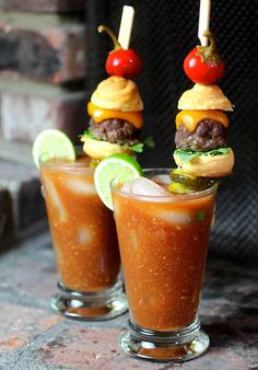 two glasses filled with food sitting on top of a stone table next to each other