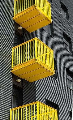 three yellow balconies on the side of a building