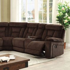 a living room with a large sectional couch and coffee table in front of the window