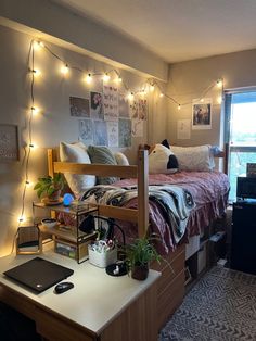 a dorm room with lights strung from the ceiling and a desk in front of it