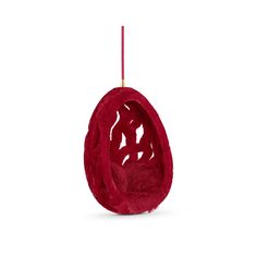 an egg chair hanging from a red cord