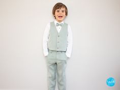 The 4-piece boys' outfit consists of: 1. long pants (chinos) with side pockets, 2. a children's bow tie, 3. a vest and 4. a white shirt with stand-up collar or Kent collar.  * Optionally: - a jacket/jacket 1. the classic trousers are adjustable on the inside. The chinos are fastened with a zipper and a wooden button.  2. a classic linen bow tie, which is attached to the collar with a pin with a safety catch. Dimensions: 5 x 9 cm (one size fits all) 3. the linen vest has a straight hem and is fas Spring Tuxedo Fitted Pants, Spring Tuxedo Style Fitted Pants, Fitted Cotton Pants For Wedding, Fitted Cotton Wedding Pants, Spring Green Cotton Suits, Toddler Suit, Vest And Bow Tie, Toddler Suits