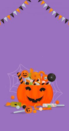 a purple background with an orange pumpkin and some candy on the ground next to it