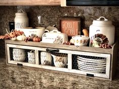 the kitchen counter is covered with dishes and other items that are sitting on it's shelf