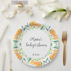 a plate with the names of two baby showerers on it next to some flowers