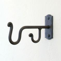 an iron hook on the side of a white wall