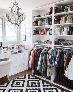 a closet filled with lots of clothes and handbags