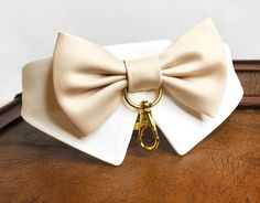 a white bow tie on top of a wooden table