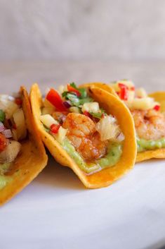 three tortilla shells with shrimp, pineapple salsa and guacamole