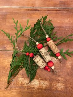 some wine corks are laying on a wooden table with pine needles and red berries