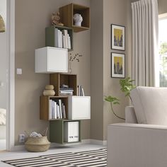 a living room filled with furniture next to a white chair and wall mounted bookshelf