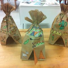 three bags with designs on them sitting on top of a wooden table next to each other