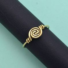 "Cute spiral ring of Brass, handcrafted and lightweight. Stack with other gemstone rings, or wear it alone. ❥ The spiral is one of the oldest symbols in the world. It appears in most ancient cultures across the globe and has many meanings, including progress, direction, and expansion. The Greeks related spirals to infinity, balance, and awareness. ❥ Benefits of Brass Metal : Brass has metaphysical healing properties to boost the immune system and to give courage. It's known to help reduce inflammation and also improve digestion. Brass has the properties of purifying negative energy.  The golden shine symbolizes the sun. It will be useful when you want to clear out shadiness in your mind. ❥ Our products are made of high-quality Brass metal and are carefully crafted by hand in our family wor Minimalist Spiral Metal Ring Jewelry, Hand Forged Spiral Jewelry Gift, Symbolic Adjustable Spiral Jewelry, Adjustable Symbolic Spiral Jewelry, Handmade Adjustable Swirl Jewelry, Handmade Spiral Minimalist Rings, Handmade Spiral Minimalist Jewelry, Handmade Minimalist Spiral Rings, Handmade Minimalist Spiral Jewelry