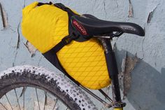 a close up of a bike with a yellow bag on the front tire and seat