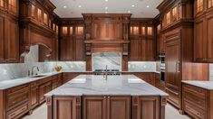 a large kitchen with wooden cabinets and marble counter tops