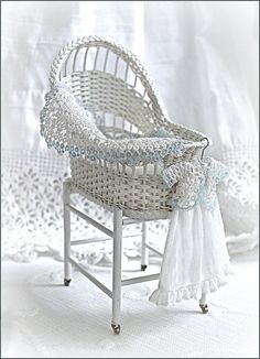 a white wicker baby's pram with blue trimmings on it