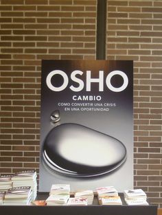 a table with books on it in front of a sign that says osho cambio