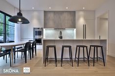 a modern kitchen with bar stools and an island