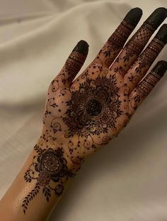 a woman's hand with henna tattoos on it