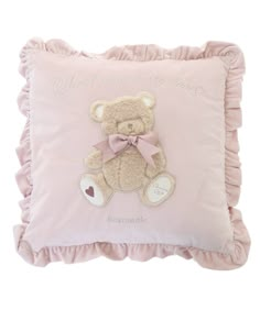 a pink pillow with a teddy bear on it