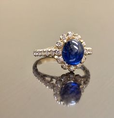 "DeKara Designs Collection Art Deco Inspired Extremely Elegant Halo Opal Diamond Engagement Ring. Metal- 90% Platinum, 10% Iridium. Stones- 1 Natural Oval Cabochon Ceylon Blue Sapphire 2.85 Carats, 26 Round Diamonds F-G Color VS1 Clarity 0.65 Carats. Size- 4-12 An Amazing Art Deco Inspired Ceylon Blue Sapphire Halo Diamond Engagement Ring Made in 18K Yellow Gold. The ring features a beautiful a beautiful Ceylon Blue Sapphire that is Oval in shape and cabochon cut. The sapphire is gracefully set Luxury Gold Diamond Cabochons, Yellow Gold Diamond Cabochons Fine Jewelry, Luxury Yellow Gold Gemstone Cabochon, Formal Hallmarked Diamond Cabochons, Oval Gold Diamond Cabochons, Luxury White Gold Diamond Cabochons, Fine Jewelry Yellow Gold Cabochons For Formal Occasions, Luxury Hallmarked Oval Cabochon Sapphire Ring, Classic Yellow Gold Cabochons For Anniversary