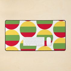 a computer mouse pad with a colorful polka dot pattern and a white keyboard on it