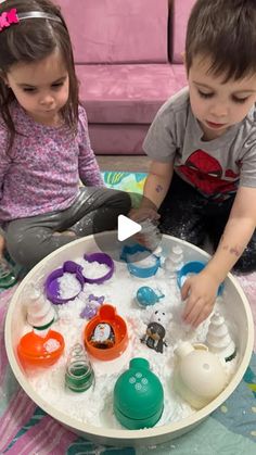 two young children playing with toys in a bowl