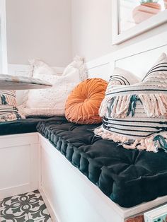 several pillows on a bench in a room