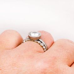 a close up of a person's hand with a ring on their finger,