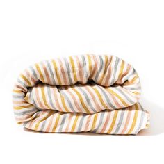 three blankets folded on top of each other in different colors and patterns, one is striped