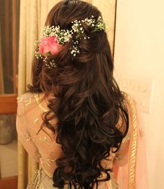 the back of a woman's head with flowers in her hair, wearing a bridal gown