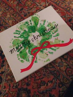 a handprinted christmas card with the words merry christmas on it and a red ribbon