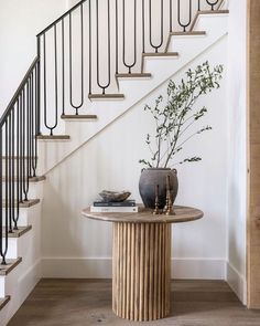 there is a vase on the table next to the stairs